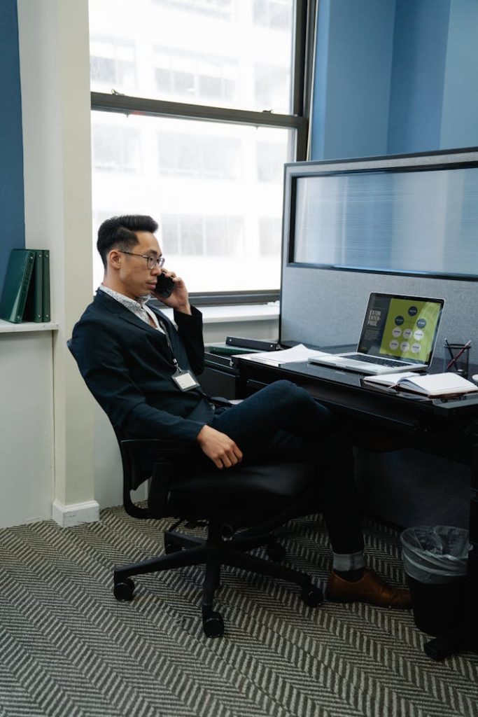 Businessman in office setting on phone call, focusing on work tasks.
